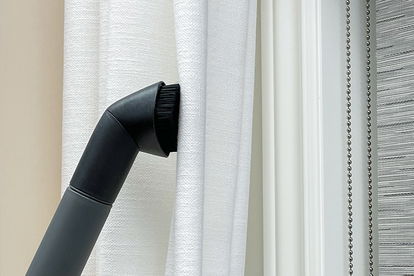 L'accessoire sous vide est utilisé pour nettoyer un rideau.