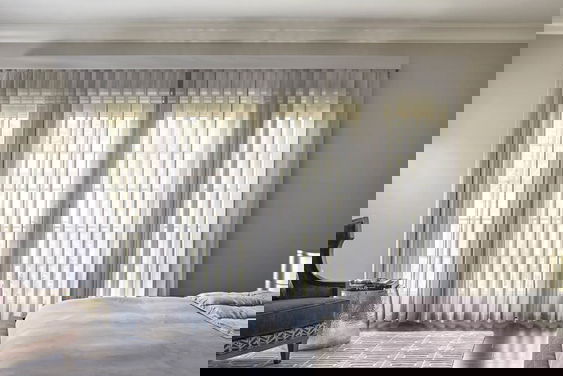 Élégants stores verticaux Melody en blanc doux, offrant filtrage de la lumière et intimité pour les grandes fenêtres.