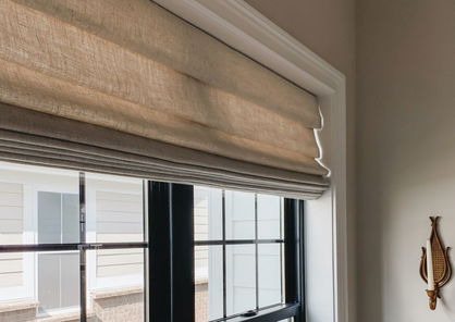 Des stores romains de couleur beige donnent le ton dans un salon moderne. 