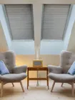 Stores pour puits de lumière Skylight shades in a room with two chairs, adding style and light control to the space